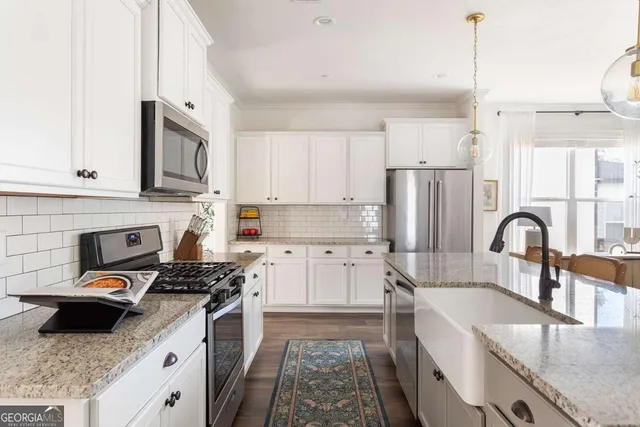 a kitchen with granite countertop a stove top oven a sink dishwasher and a refrigerator with wooden floor