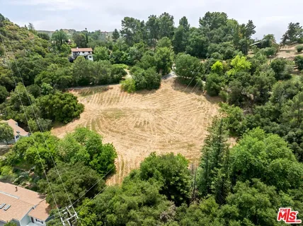 an aerial view of residential house with yard and outdoor seating