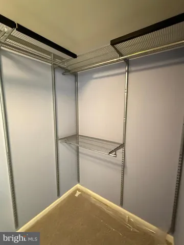 a view of an empty room with closet and utility area