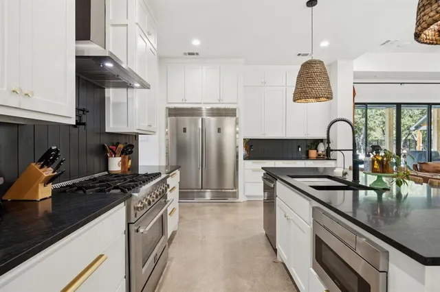 a kitchen with granite countertop a sink stainless steel appliances and cabinets