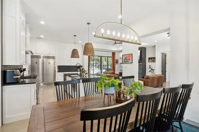 a view of a dining room with furniture a kitchen and chandelier
