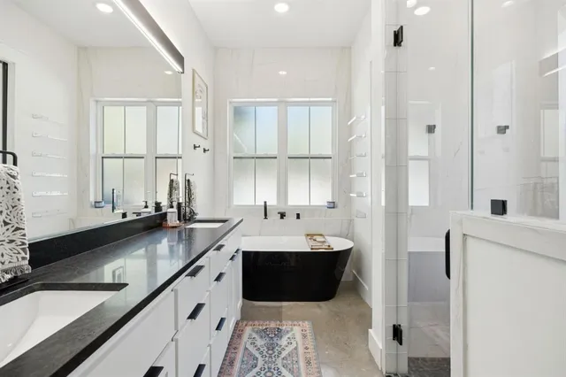 a spacious bathroom with a double vanity sink a mirror and a bathtub