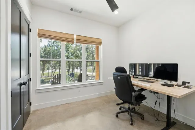 a view of a workspace with furniture and a window