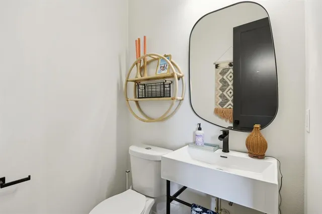 a bathroom with a toilet a sink and a mirror