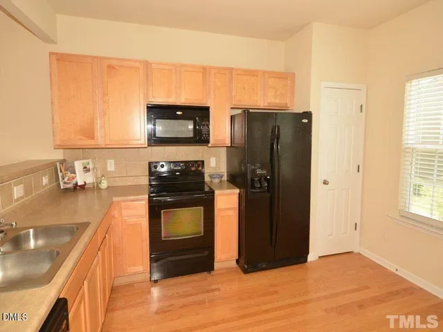 a kitchen with stainless steel appliances granite countertop a refrigerator stove and sink