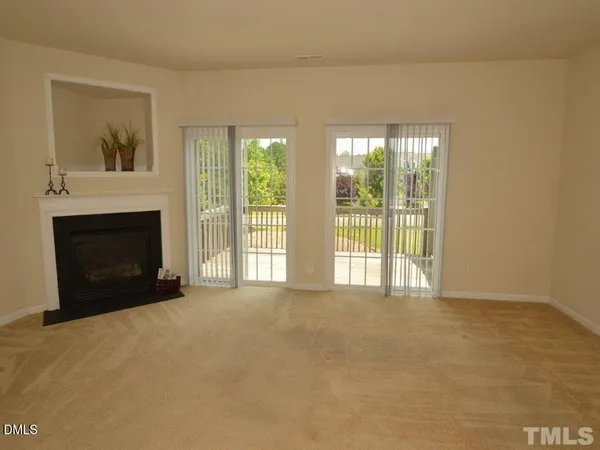 a view of an empty room with a fireplace and a window