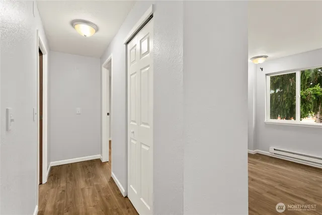 a view of hallway with a large window and wooden floor
