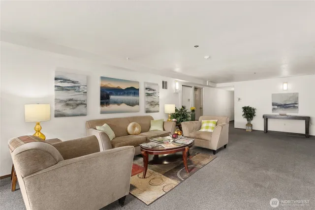 a living room with furniture a rug and a lamp