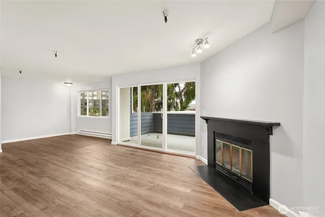 a view of an empty room with a fireplace and a window