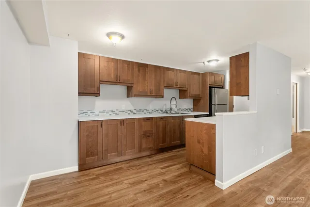 a kitchen with granite countertop a sink cabinets and wooden floor