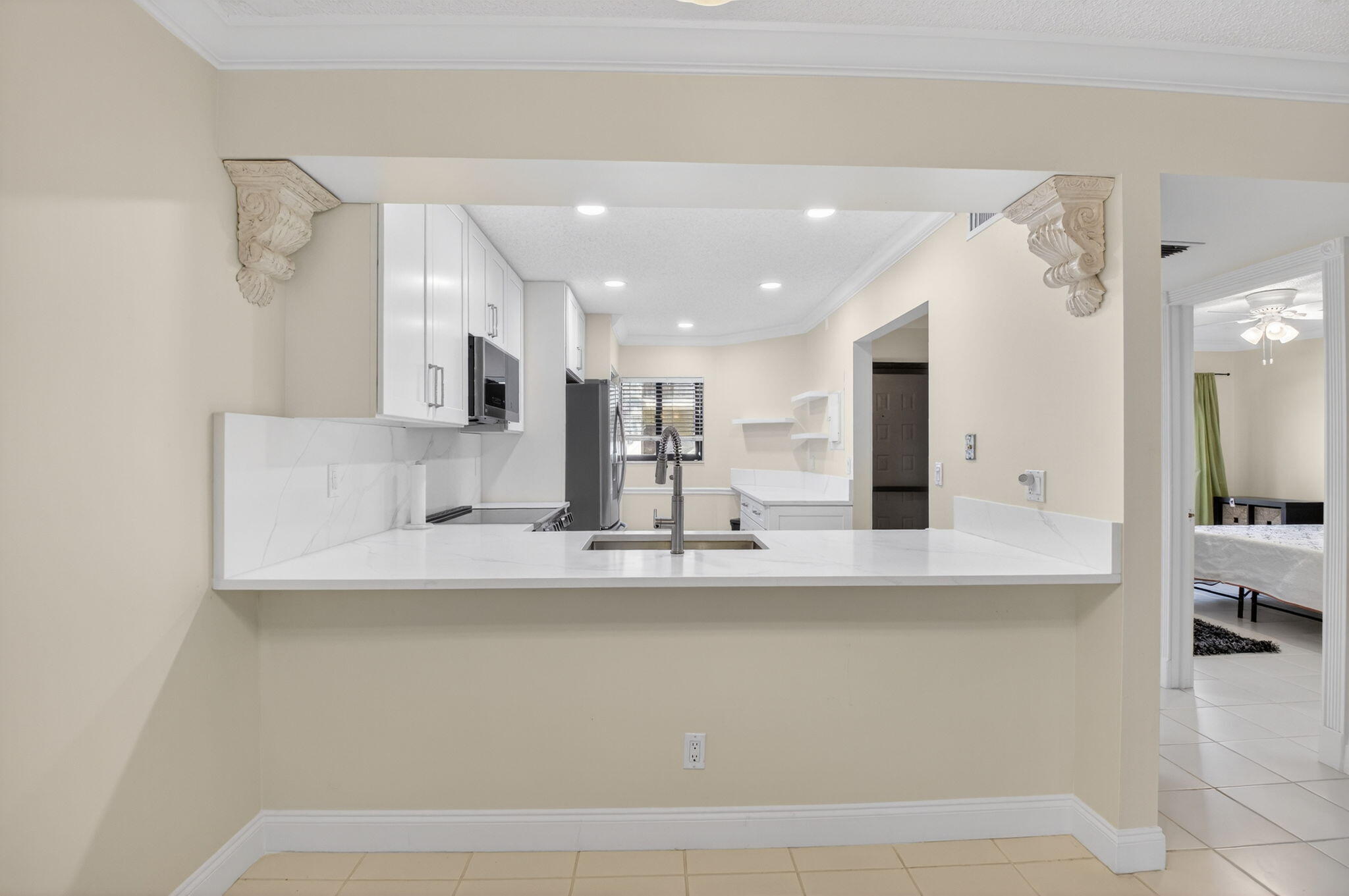 159 Northwest 70th Street, Unit 403 Boca Raton, FL 33487 - Photo 7 of 30 a large white kitchen with kitchen island a sink stainless steel appliances and cabinets