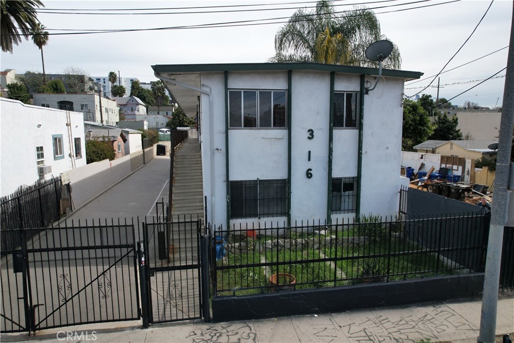 a view of a house with a small yard and wooden fence