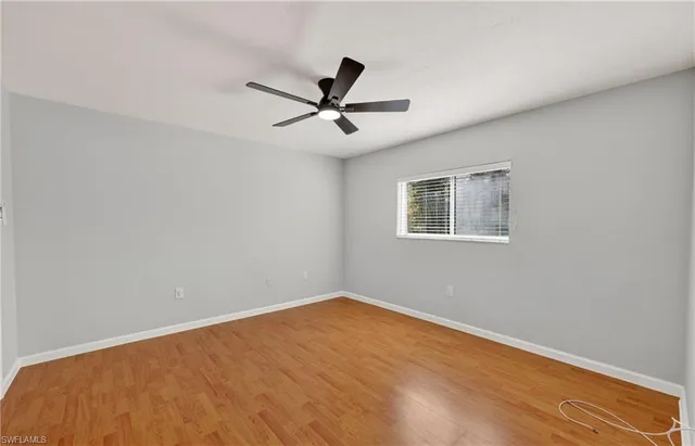 a view of a big room with wooden floor and windows