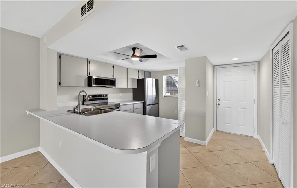144 Cypress Way East, Unit 701 Naples, FL 34110 - Photo 2 of 36 a kitchen with stainless steel appliances a refrigerator sink and stove