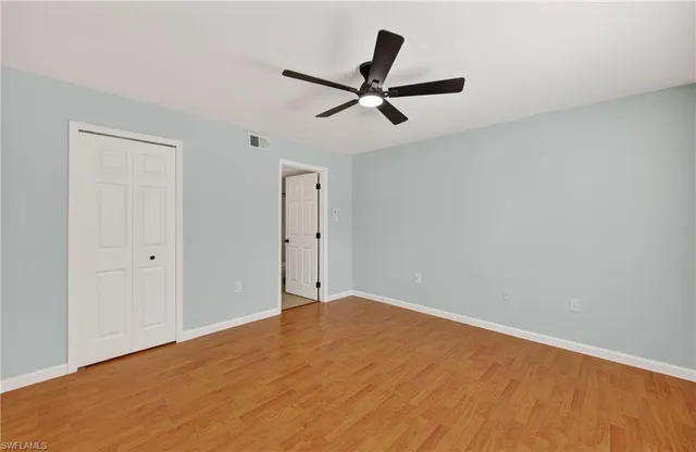 a view of a big room with wooden floor and windows