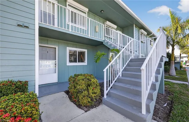 a view of a house with wooden stairs and a table and chairs