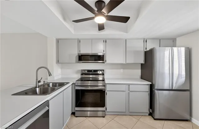 a kitchen with stainless steel appliances a refrigerator sink and white cabinets