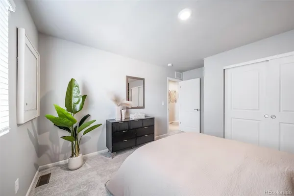 a bedroom with a bed and a potted plant