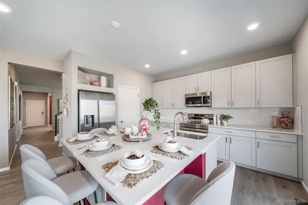 a kitchen with a dining table chairs refrigerator and cabinets