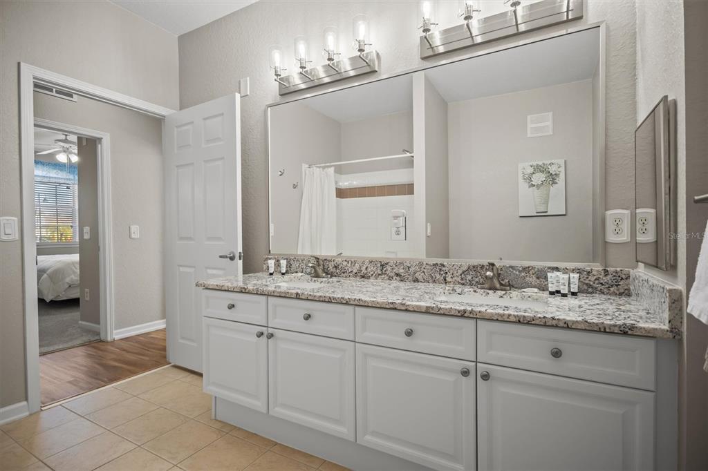 301 Terrace Ridge Circle, Unit 301 Davenport, FL 33896 - Photo 18 of 35 a bathroom with a granite countertop sink and a mirror