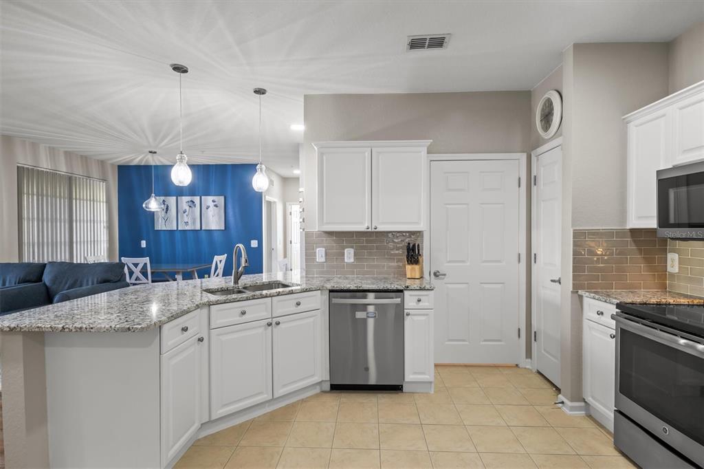 301 Terrace Ridge Circle, Unit 301 Davenport, FL 33896 - Photo 6 of 35 a kitchen with stainless steel appliances a sink stove and refrigerator
