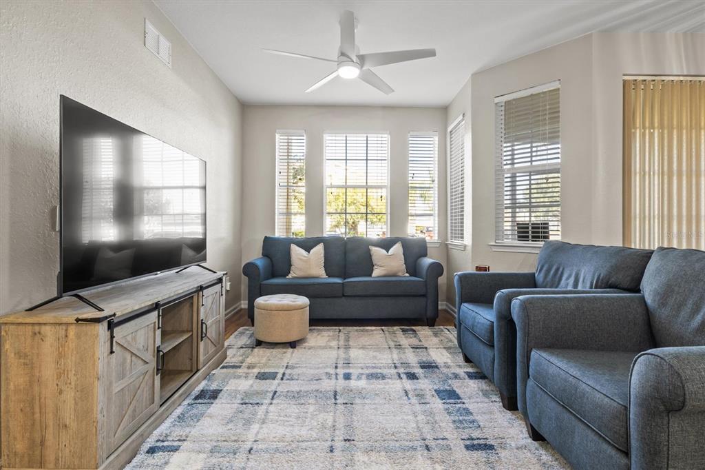 301 Terrace Ridge Circle, Unit 301 Davenport, FL 33896 - Photo 7 of 35 a living room with furniture and a flat screen tv