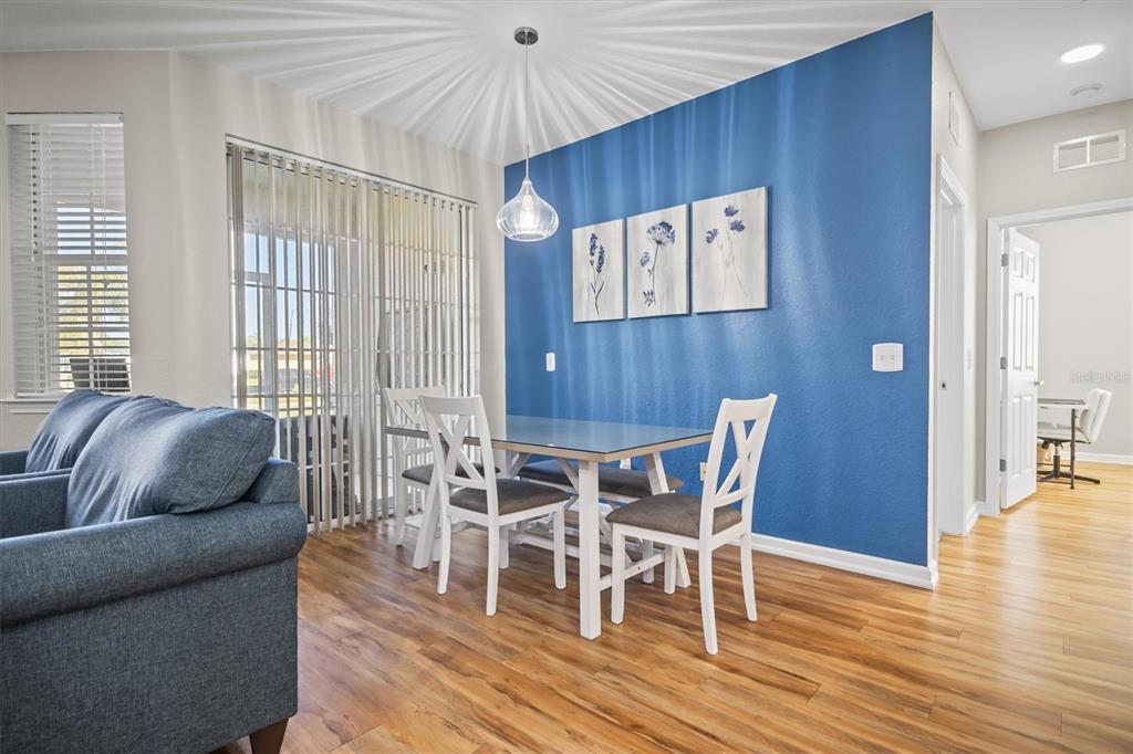 301 Terrace Ridge Circle, Unit 301 Davenport, FL 33896 - Photo 9 of 35 a living room with furniture a wooden floor and a chandelier