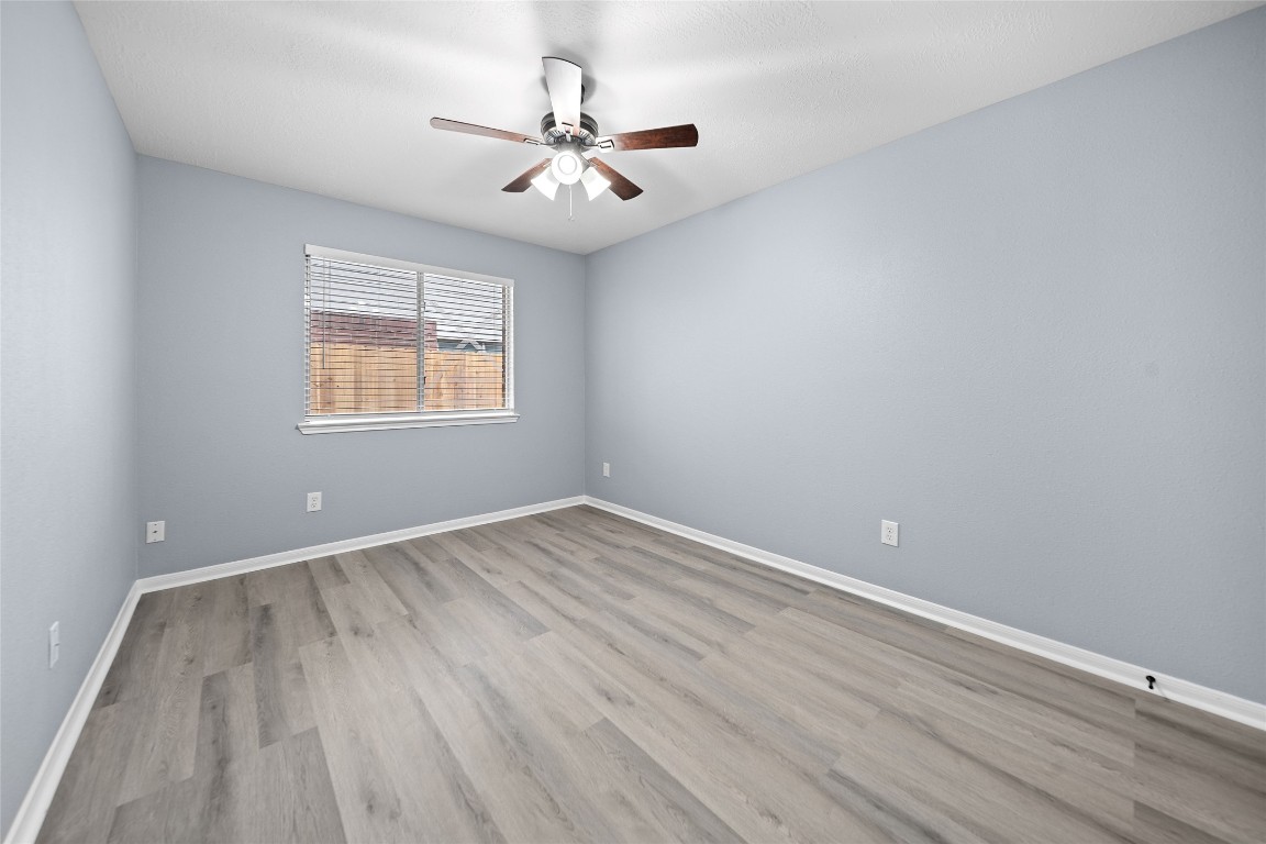 6627 Greenhouse Road Katy, TX 77449 - Photo 12 of 23 an empty room with wooden floor and windows