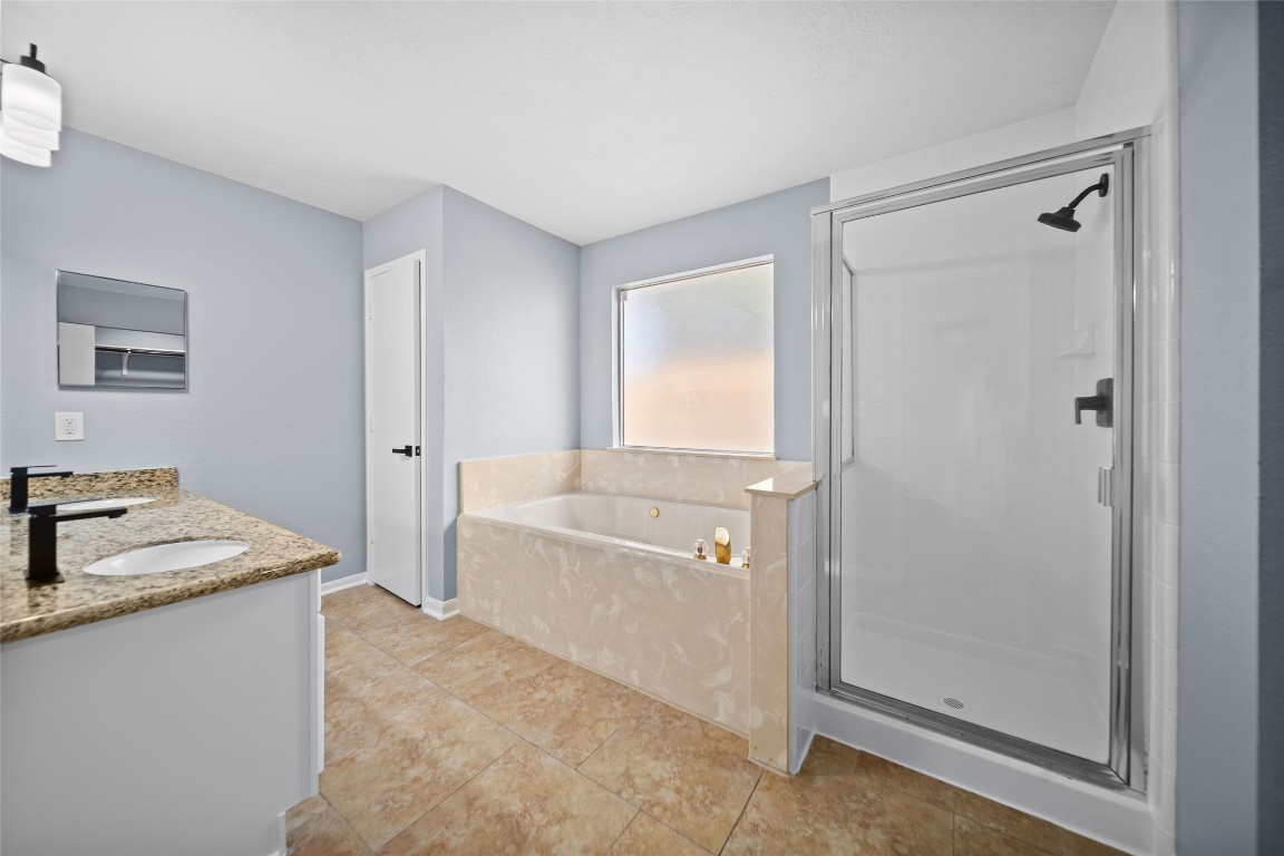 6627 Greenhouse Road Katy, TX 77449 - Photo 14 of 23 a bathroom with a granite countertop sink a mirror and a bathtub