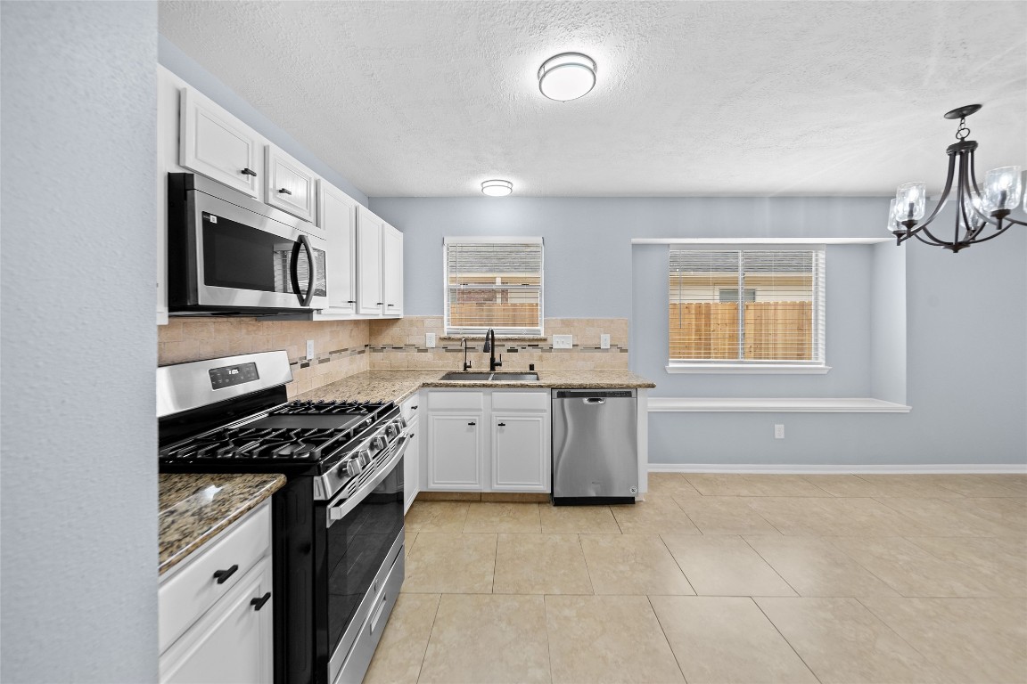 6627 Greenhouse Road Katy, TX 77449 - Photo 16 of 23 a kitchen with granite countertop a stove top oven sink and cabinets