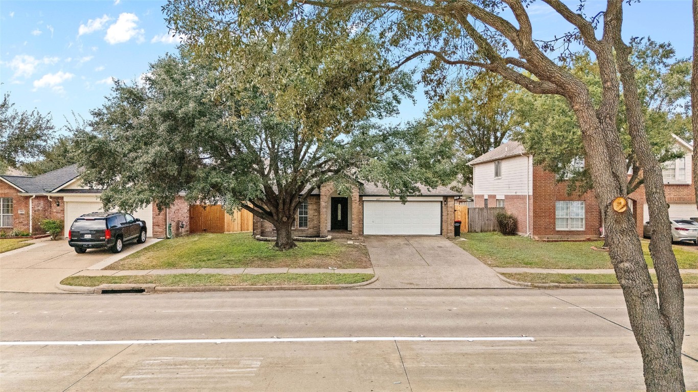 6627 Greenhouse Road Katy, TX 77449 - Photo 23 of 23 a view of a white house that has a tree on the side of the road