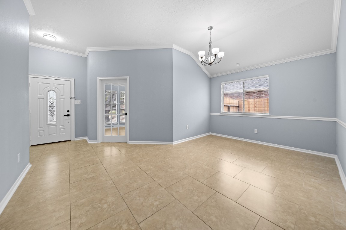 6627 Greenhouse Road Katy, TX 77449 - Photo 4 of 23 an empty room with chandelier and windows