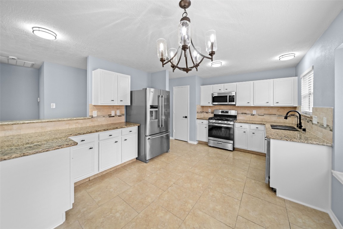 6627 Greenhouse Road Katy, TX 77449 - Photo 7 of 23 a kitchen with stainless steel appliances granite countertop a refrigerator a sink dishwasher a stove and white cabinets with wooden floor