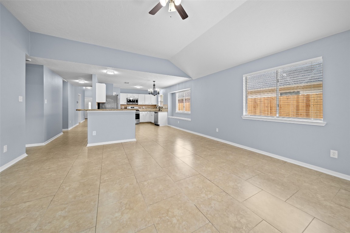 6627 Greenhouse Road Katy, TX 77449 - Photo 8 of 23 a view of a kitchen with kitchen island stainless steel appliances windows a sink and a chandelier