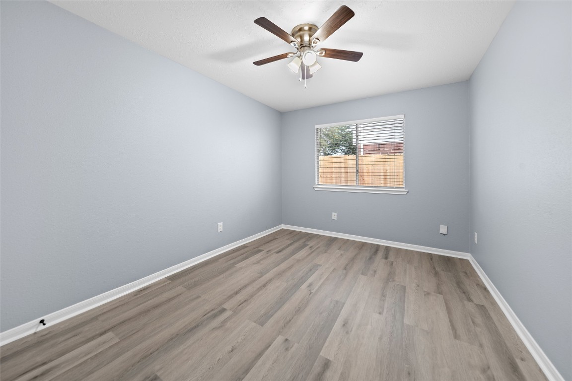 6627 Greenhouse Road Katy, TX 77449 - Photo 10 of 23 an empty room with wooden floor and windows