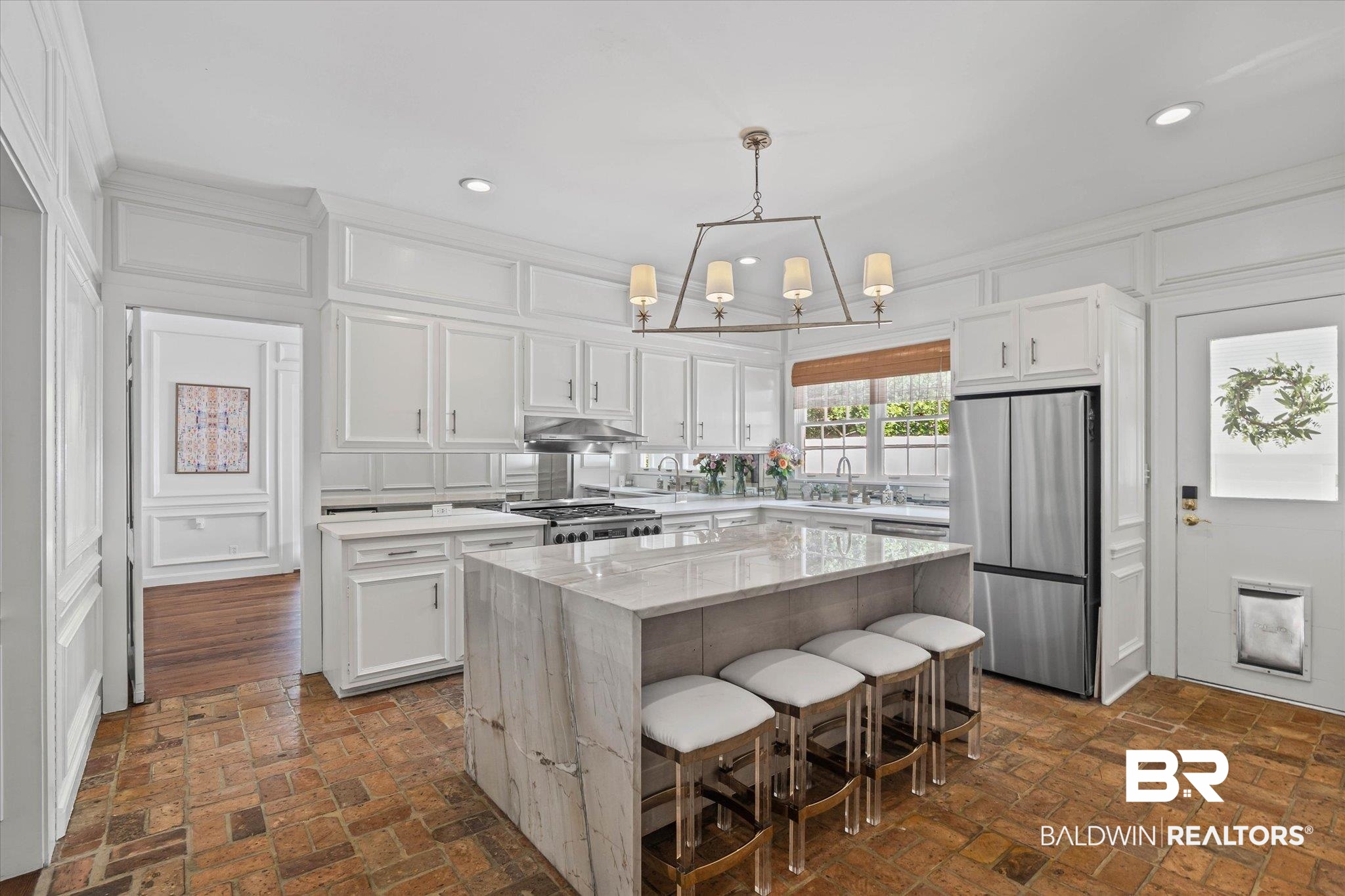 151 Tuthill Lane Mobile, AL 36608 - Photo 3 of 41 Kitchen featuring a kitchen island, white cabinets, a decorative wall, a breakfast bar area, and decorative light fixtures