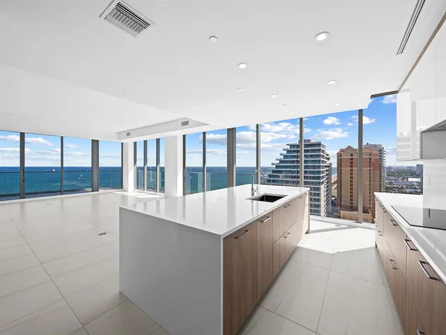 a large kitchen with kitchen island a large window a sink and counter space