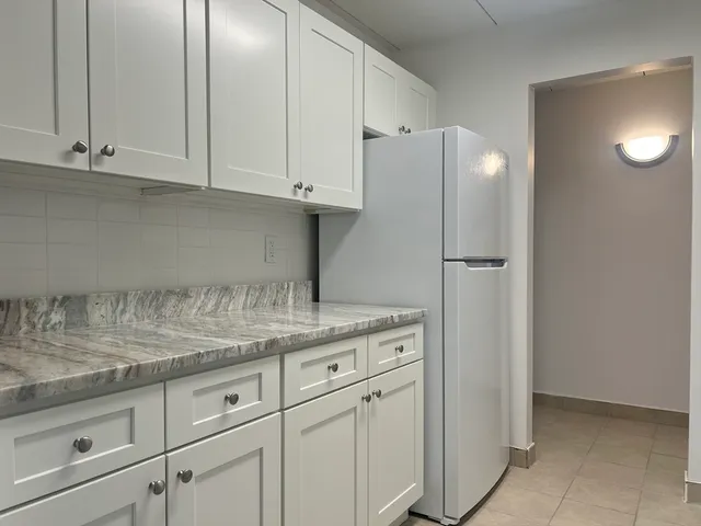 a kitchen with granite countertop white cabinets and a sink