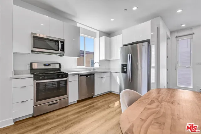 a kitchen with stainless steel appliances a refrigerator stove microwave and sink