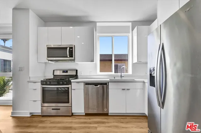 a kitchen with stainless steel appliances a stove a refrigerator and a microwave