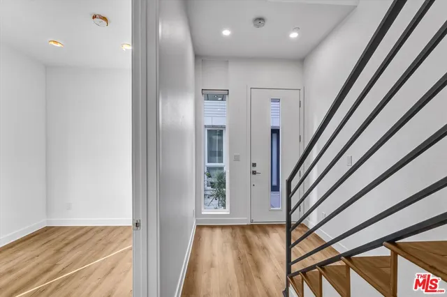 a view of hallway with wooden floor and stairs