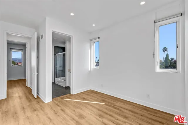 a view of a hallway with wooden floor and closet