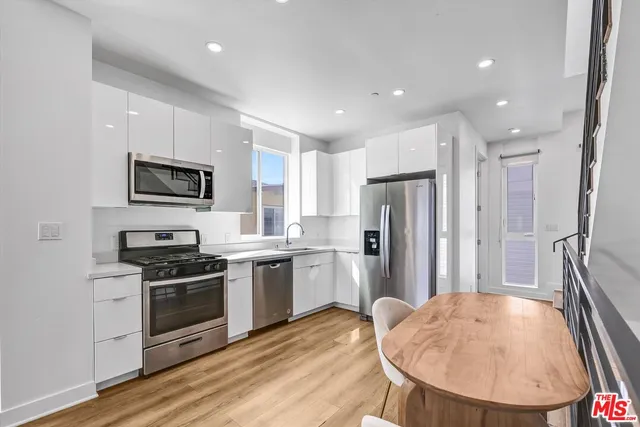 a kitchen with stainless steel appliances granite countertop a refrigerator stove top oven and sink