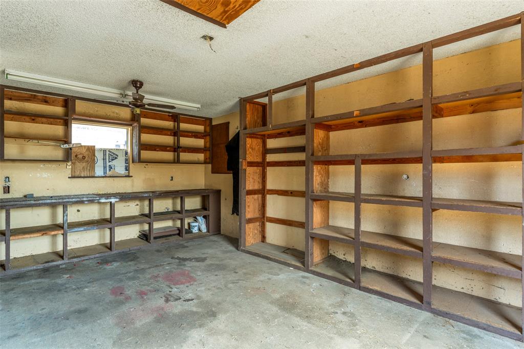 1101 Kennedale Sublett Road Kennedale, TX 76060 - Photo 32 of 35 Utility space featuring extensive built-in shelving, concrete flooring, and an integrated workbench