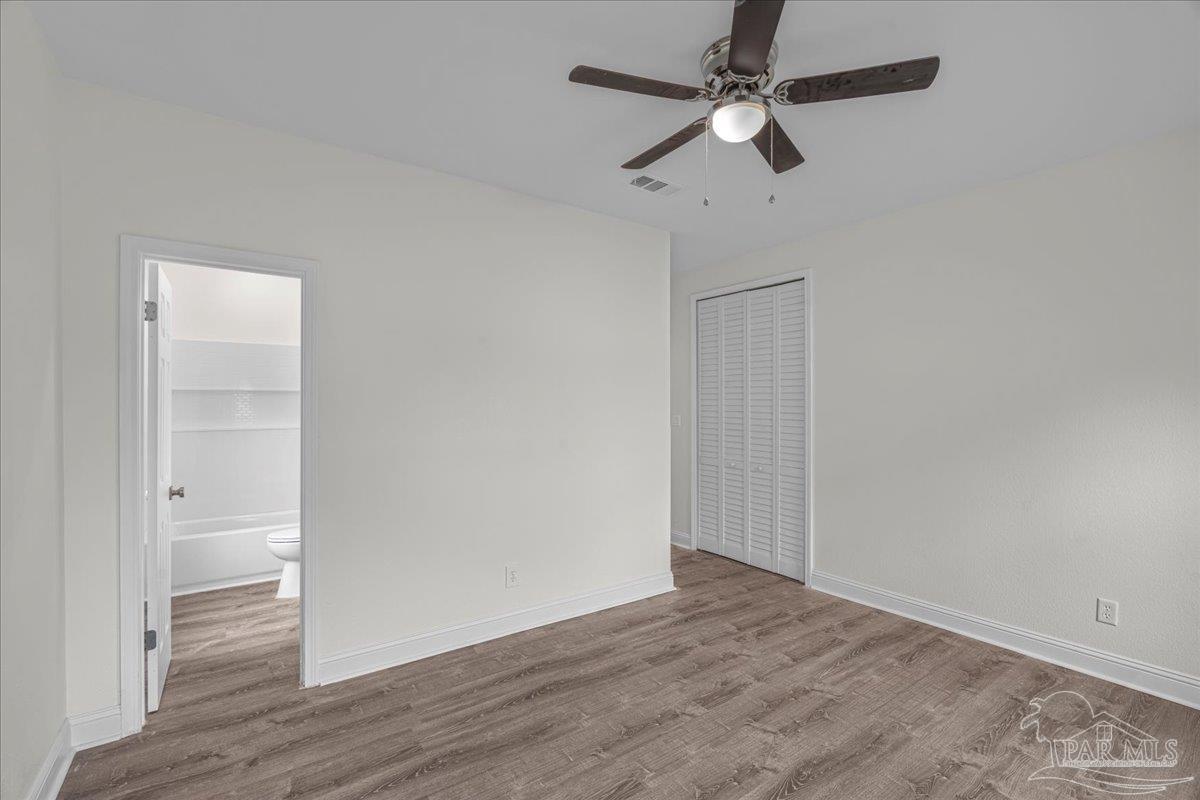 601 East Burgess Road, Unit C3 Pensacola, FL 32504 - Photo 24 of 35 an empty room with wooden floor ceiling fan and window