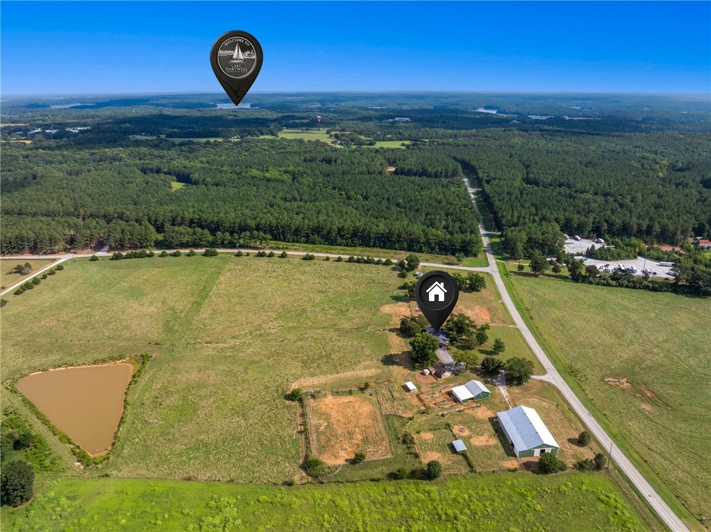 910 Highway 182 Fair Play, SC 29643 - Photo 49 of 50 An aerial perspective showcases extensive pastures and rolling green terrain bordered by mature woodlands.
