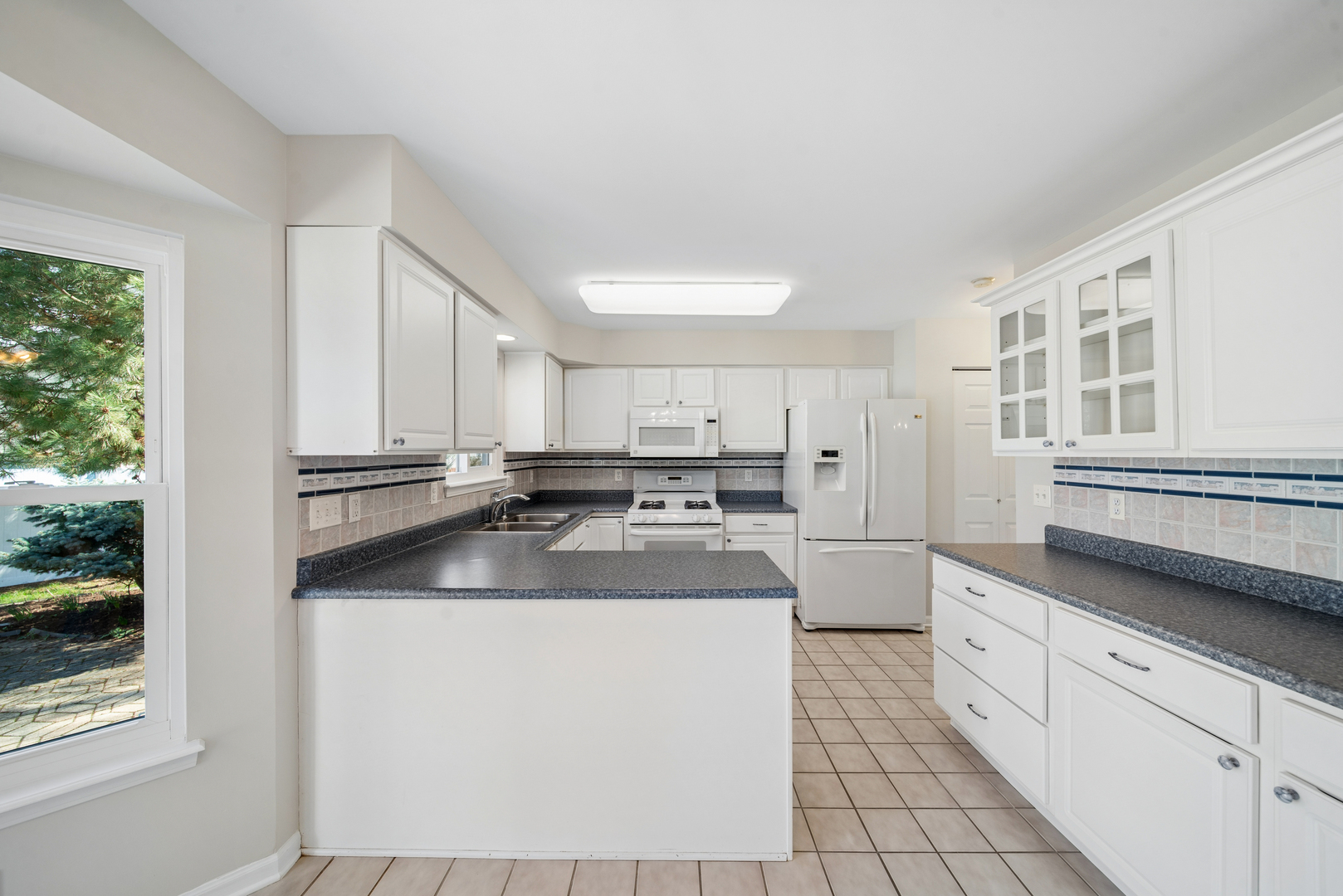 233 Spring Court North Aurora, IL 60542 - Photo 14 of 18 a kitchen with stainless steel appliances granite countertop a sink stove and white cabinets