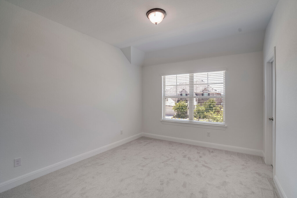 2920 Hadley Way Leander, TX 78641 - Photo 14 of 20 A well-lit bedroom with fresh, neutral carpet and window blinds offering a pleasant neighborhood view.