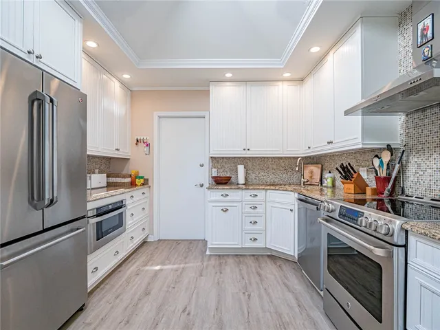 a kitchen with granite countertop stainless steel appliances a stove top oven