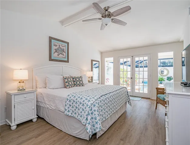 a bedroom with a large bed a chandelier and a window